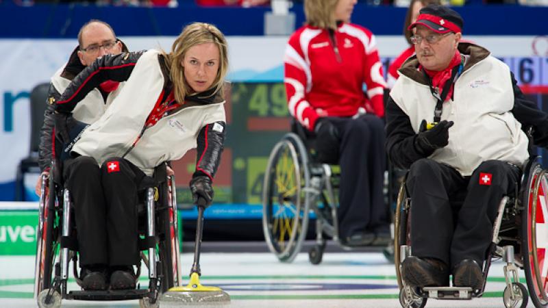 A picture of a man and a woman in a wheelchair playing curling