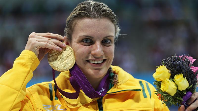 A picture of a woman showing her gold medal