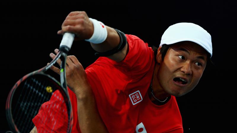 A picture of a man in a wheelchair playing tennis