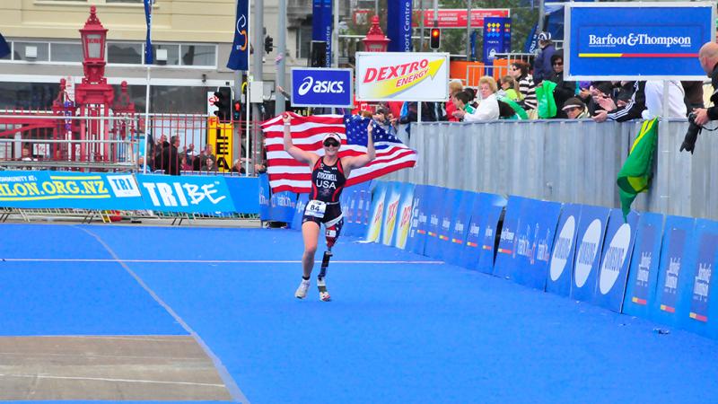 A picture of a woman with a prosthesis wearing an American flag to celebrate her victory