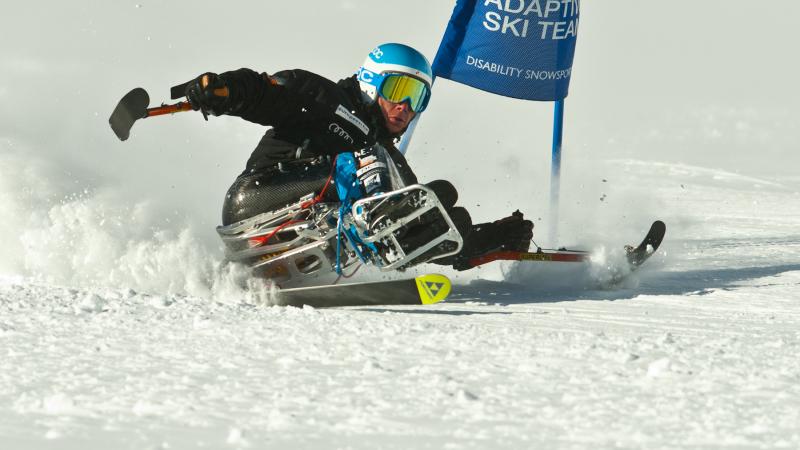 A picture of a man in a sledge skiing