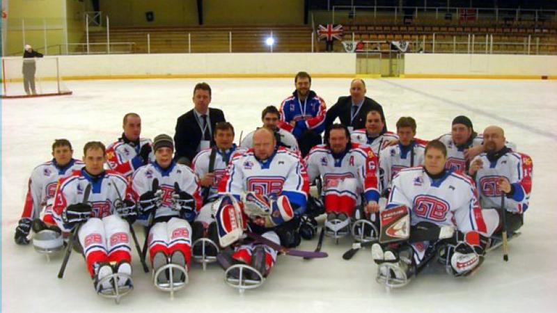 A picture of a sledge hockey team posing for a group picture