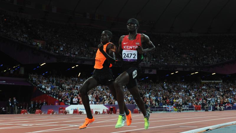 A picture of a blind man running with a guide