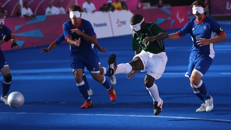 A picture of a blind person shooting the ball in a football match