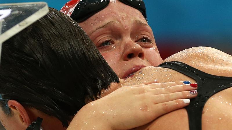 A picture of two women crying after their performances during a swimming race.