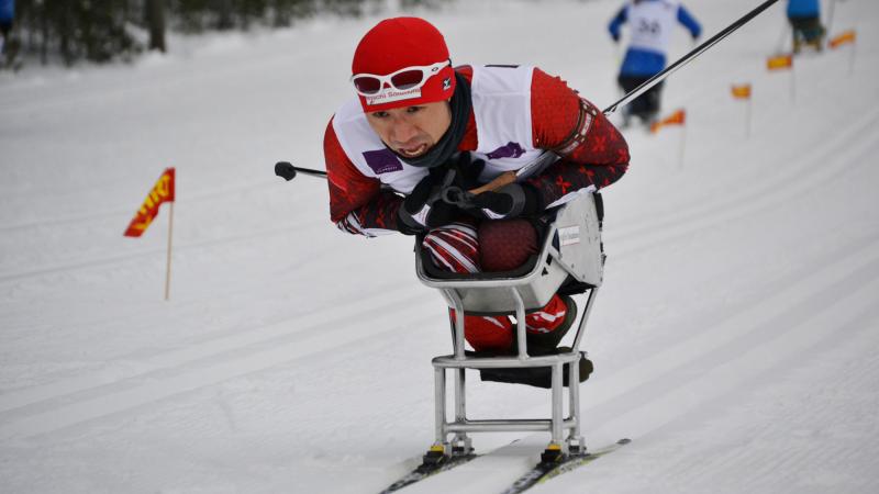 A picture of a man in a sledge skiing