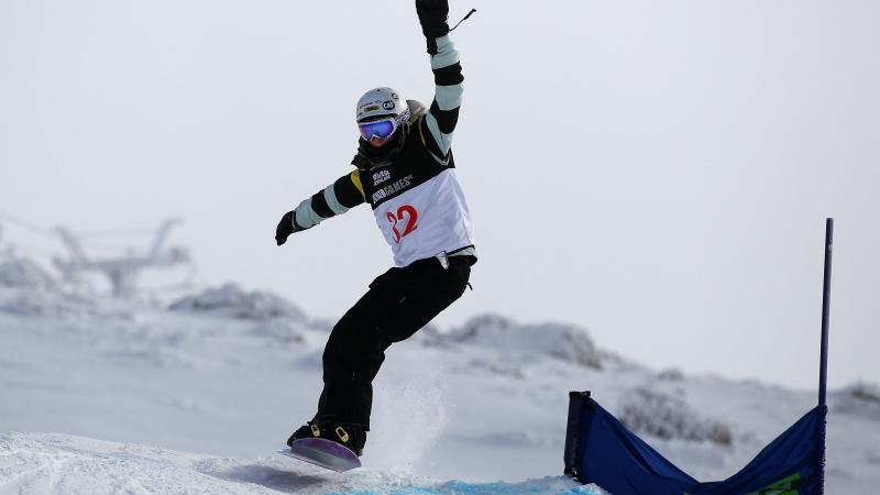 A picture of a woman jumping with a snowboard