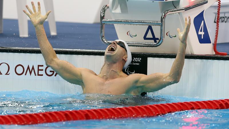 A picture of a man with his hands up in the pool