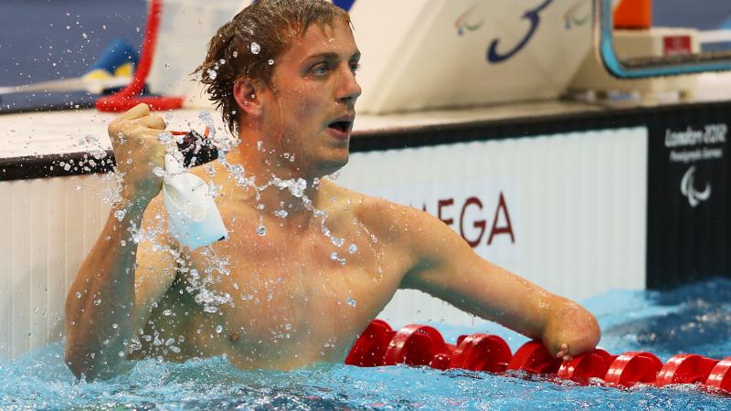 A picture of a man holding the swimming cap in his hand