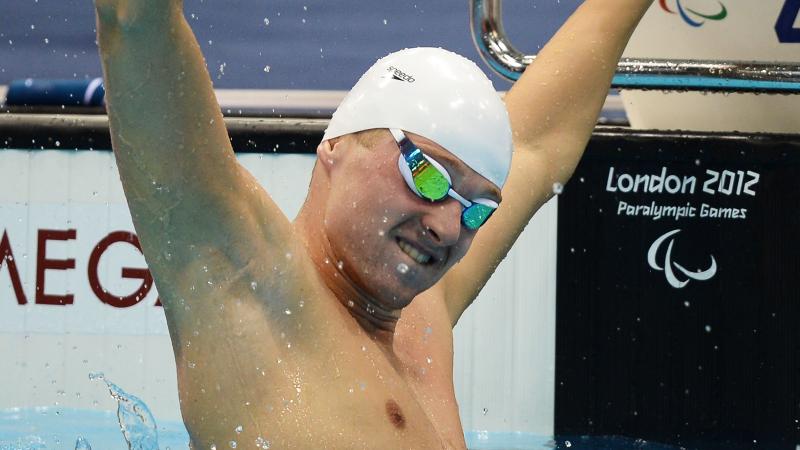 A picture of a man holding his hand up with clenched fist in the pool