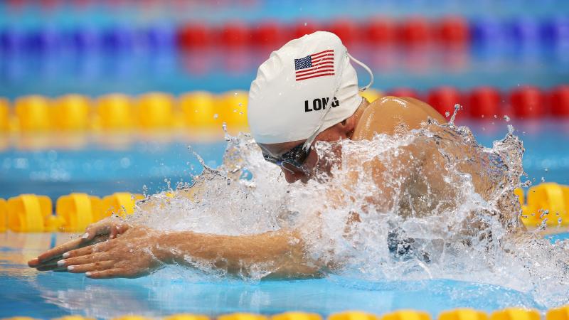 A picture of a woman in the pool with her head and hands above the surface