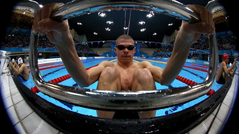 A picture of a man holding the starting block with his hands