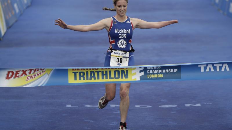 A picture of a woman crossing a finish line after a triathlon race