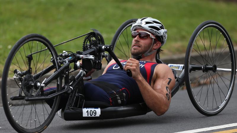 A picture of a man without leg cycling in a hand-cycle