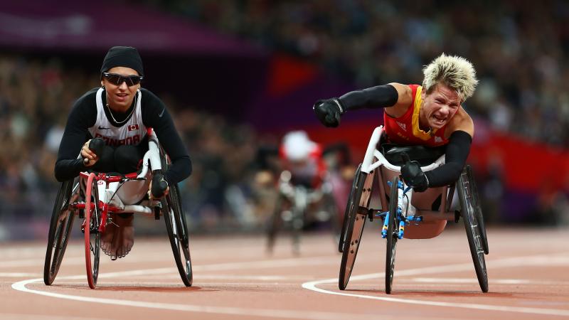 A picture of a woman in the wheelchair celebrating the victory with her hand up