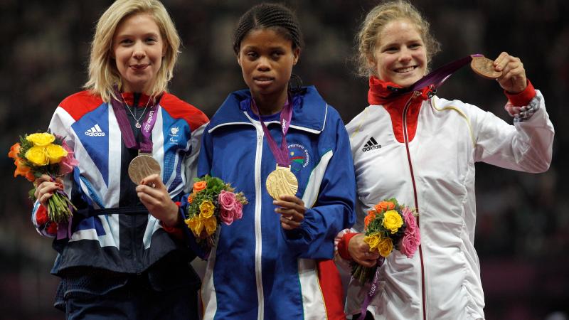 A picture of women on a podium with medals around their neck