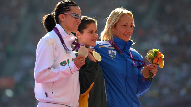 A picture of women on a podium with medals around their neck