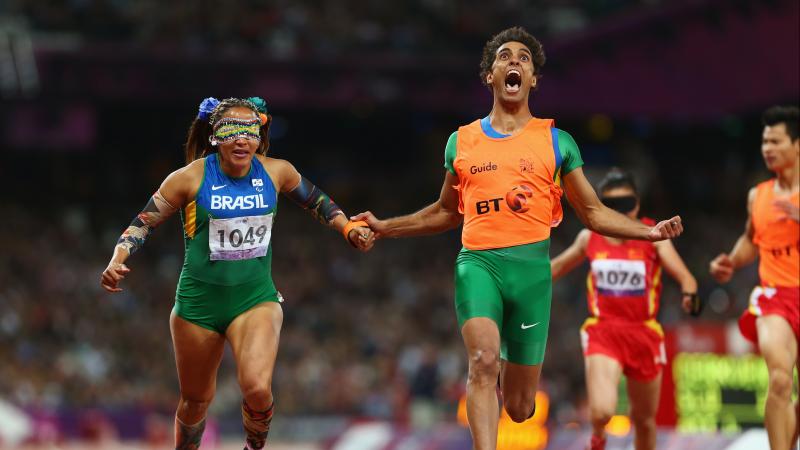 A picture of a woman with the guide running on the track