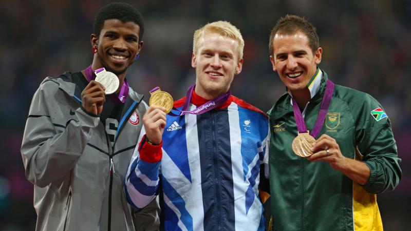 A picture of men on a podium with medals around their neck