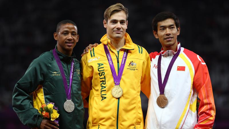 A picture of men on a podium with medals around their neck