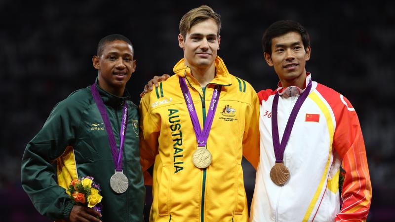 A picture of men on a podium with medals around their neck