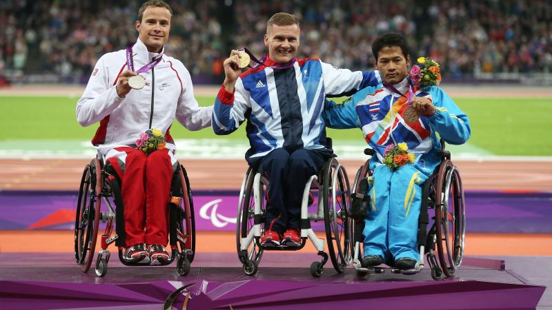 A picture of men on a podium with medals around their neck