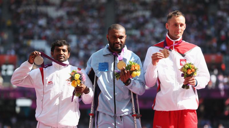 A picture of men on a podium with medals around their neck