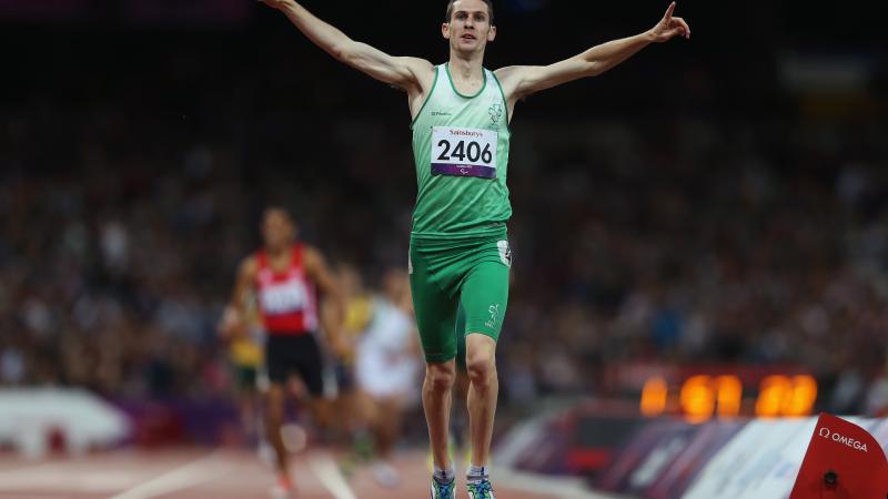 A picture of a man celebrates after crossing a finish line