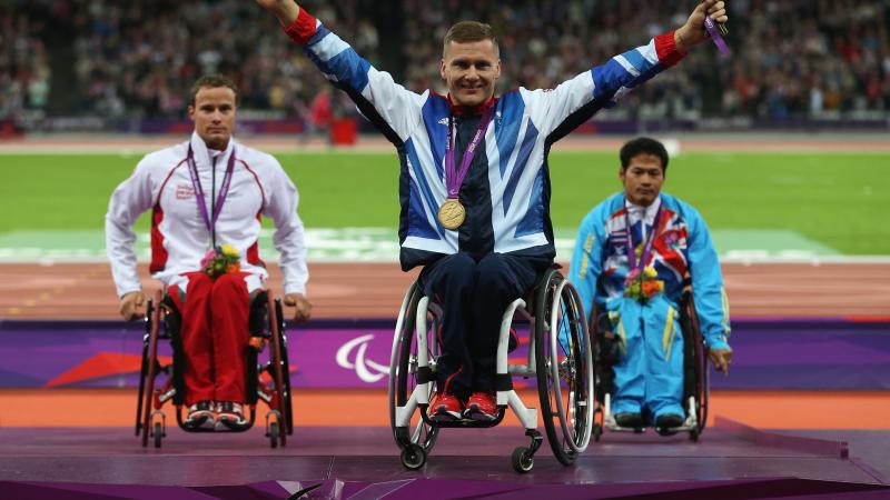 A picture of a men on a podium with medals around their neck