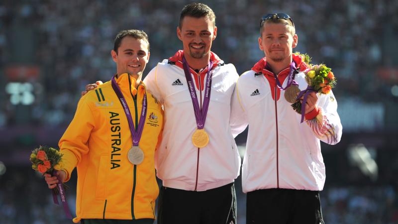 A picture of men on a podium with medals around their neck