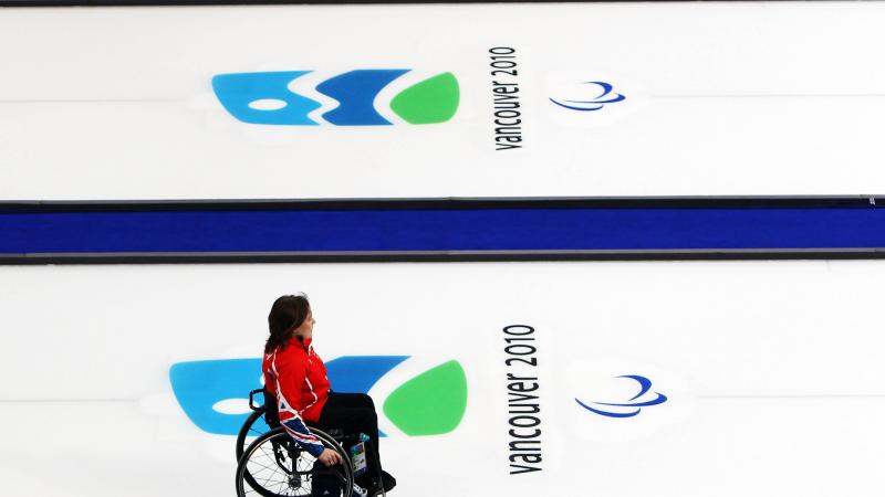 A picture of a woman in a wheelchair playing curling