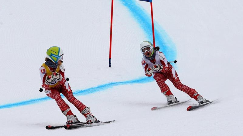 A picture of a blind woman skiing with her guide