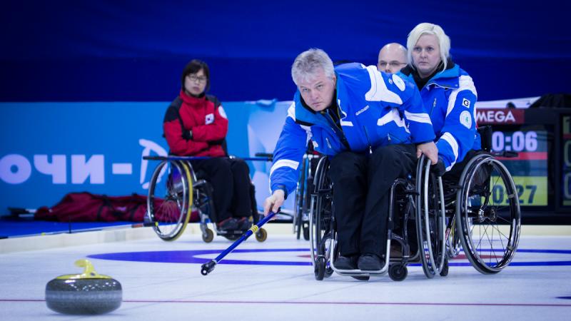 A picture of a man in a wheelchair playing curling