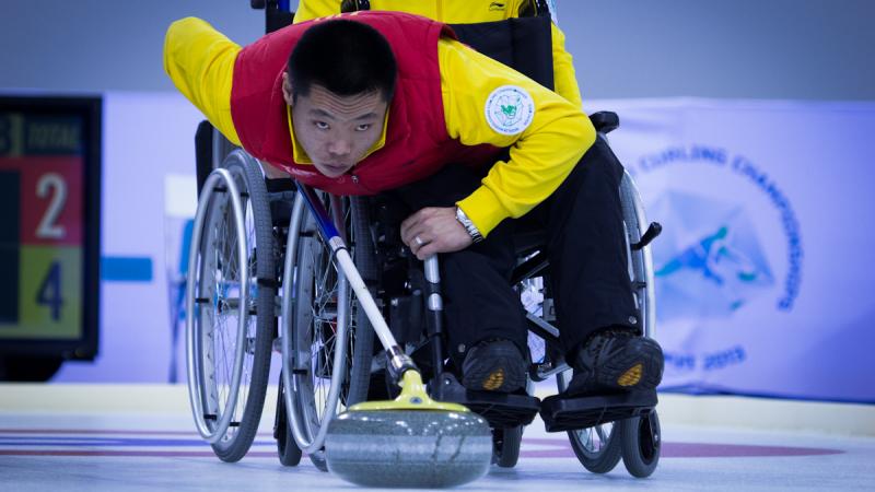 A picture of a man in a wheelchair playing curling