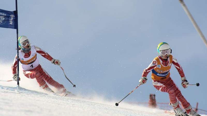 A picture of a woman skiing with her guide