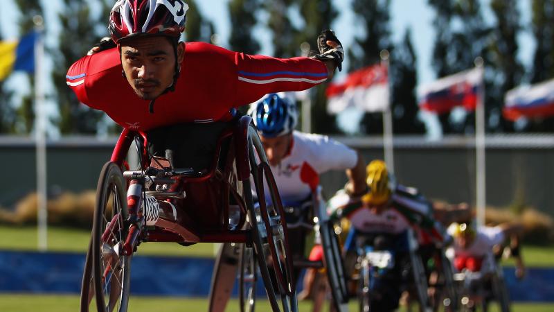 A picture of a man in a wheelchair racing on a track