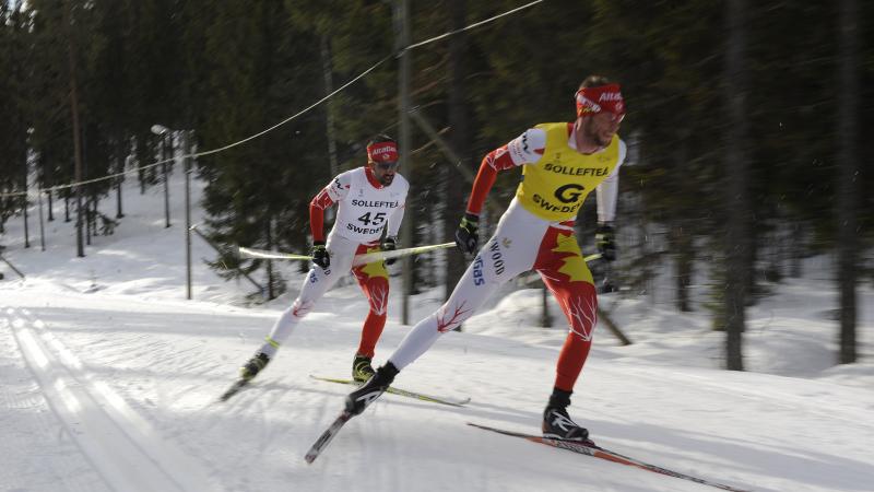 A picture of men skiing on a track