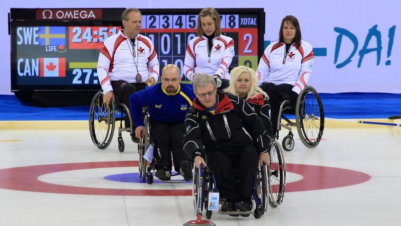 A picture of person in wheelchairs playing curling