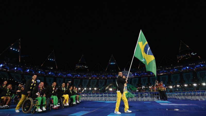 A picture of a man holding a brazilian flag