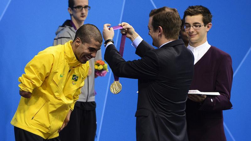 A picture of a man giving a medal to an athlete during a medal ceremony