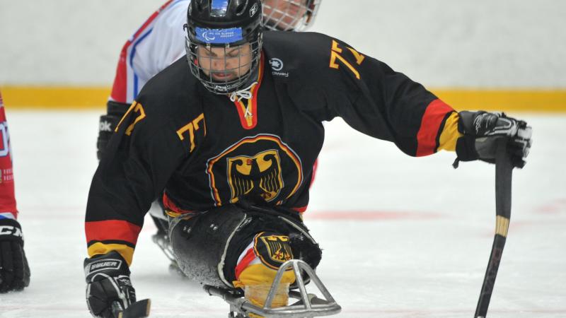 A picture of a man in ssledge playing ice hockey