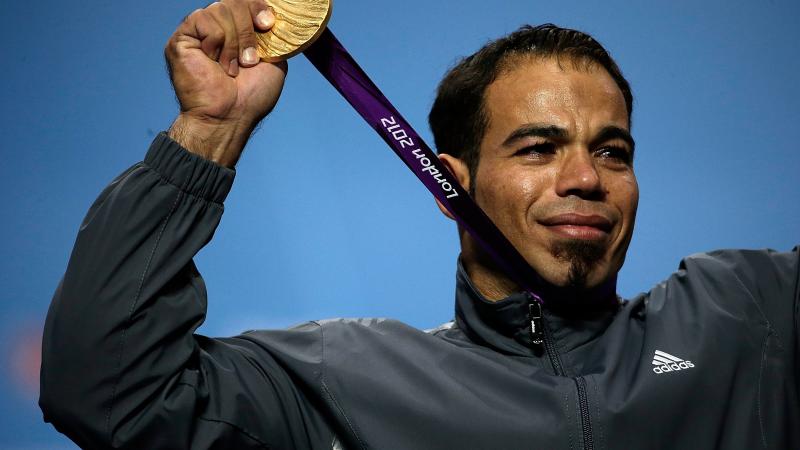 A picture of a man on a podium with a medal aorund his neck