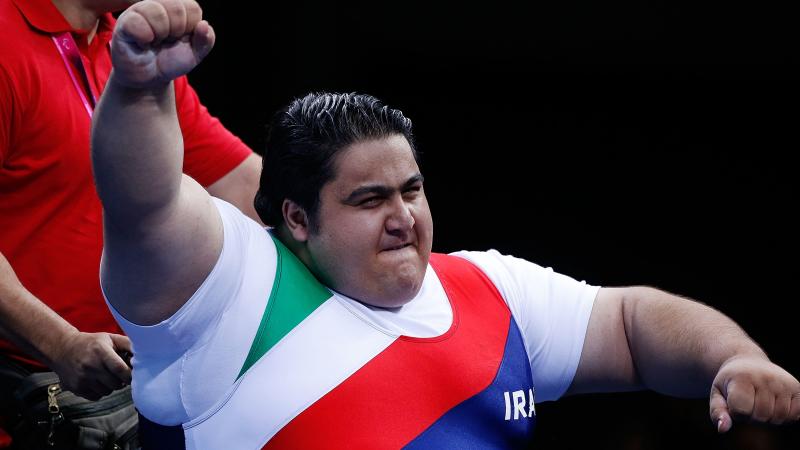 A picture of a powerlifter celebrating victory with his hand up