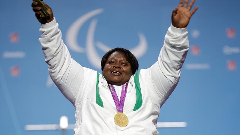 A picture of a woman on a podium with a medal around her neck