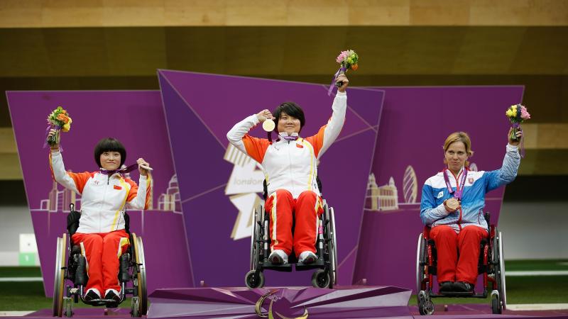 A picture of women on a podium with medals around their neck