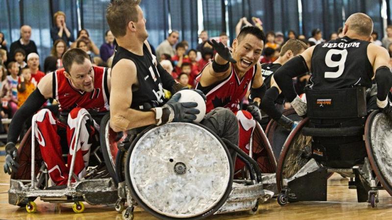 Belgium wheelchair rugby player defends ball against canadian player