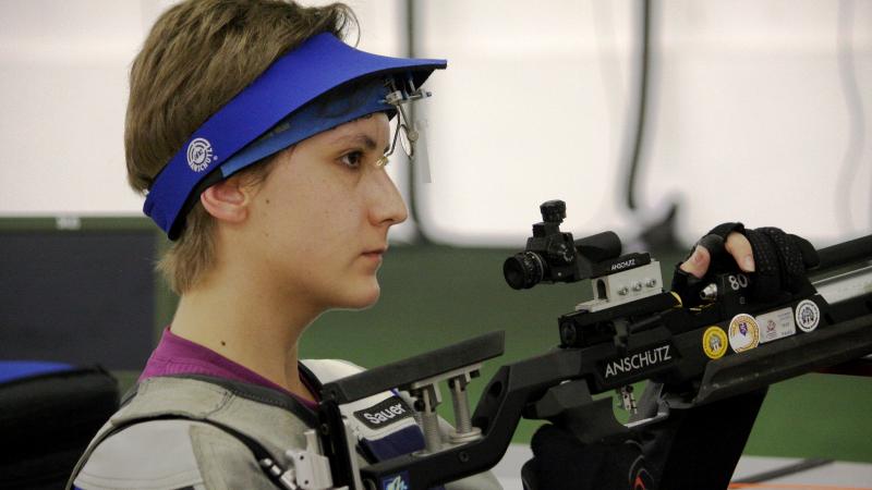 Athlete holding a rifle while practicing shooting.