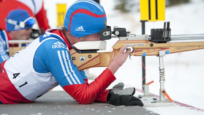 Azat Karachurin lies to shoot a gun in hte short course biathlon event