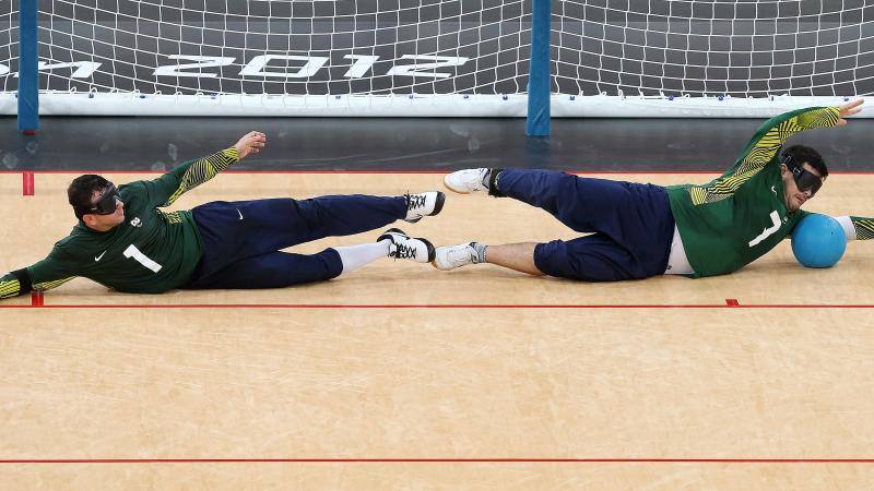 Jose Roberto Ferreira de Oliveira (L) and Filippe Santos Silvestre of Brazil dive in front of the goal during the Men's Group A Goalball match between Finland and Brazil on day 1 of the London 2012 Paralympic Games