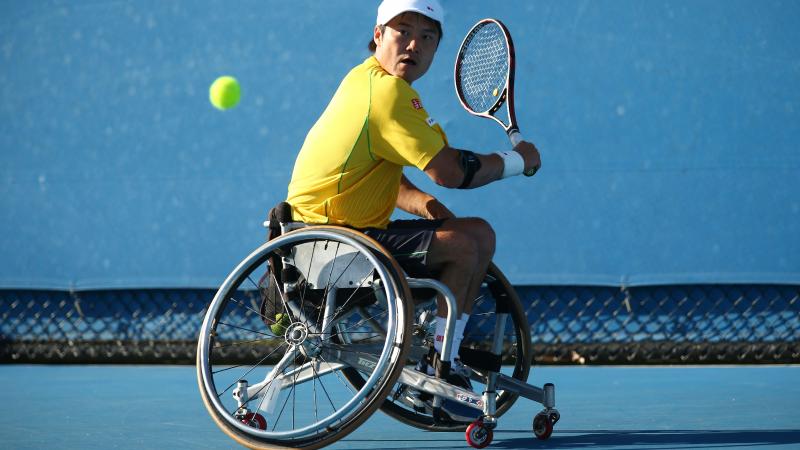 Shingo Kunieda in a wheelchair plays a backhand with his tennis racket